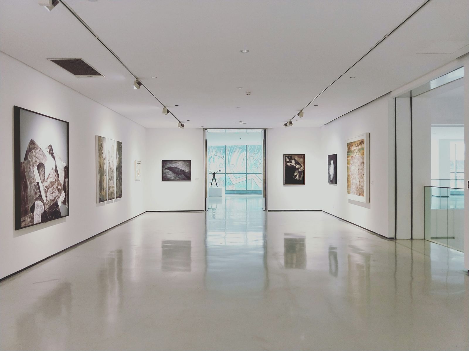An overview of a museum with painting hung on all the walls